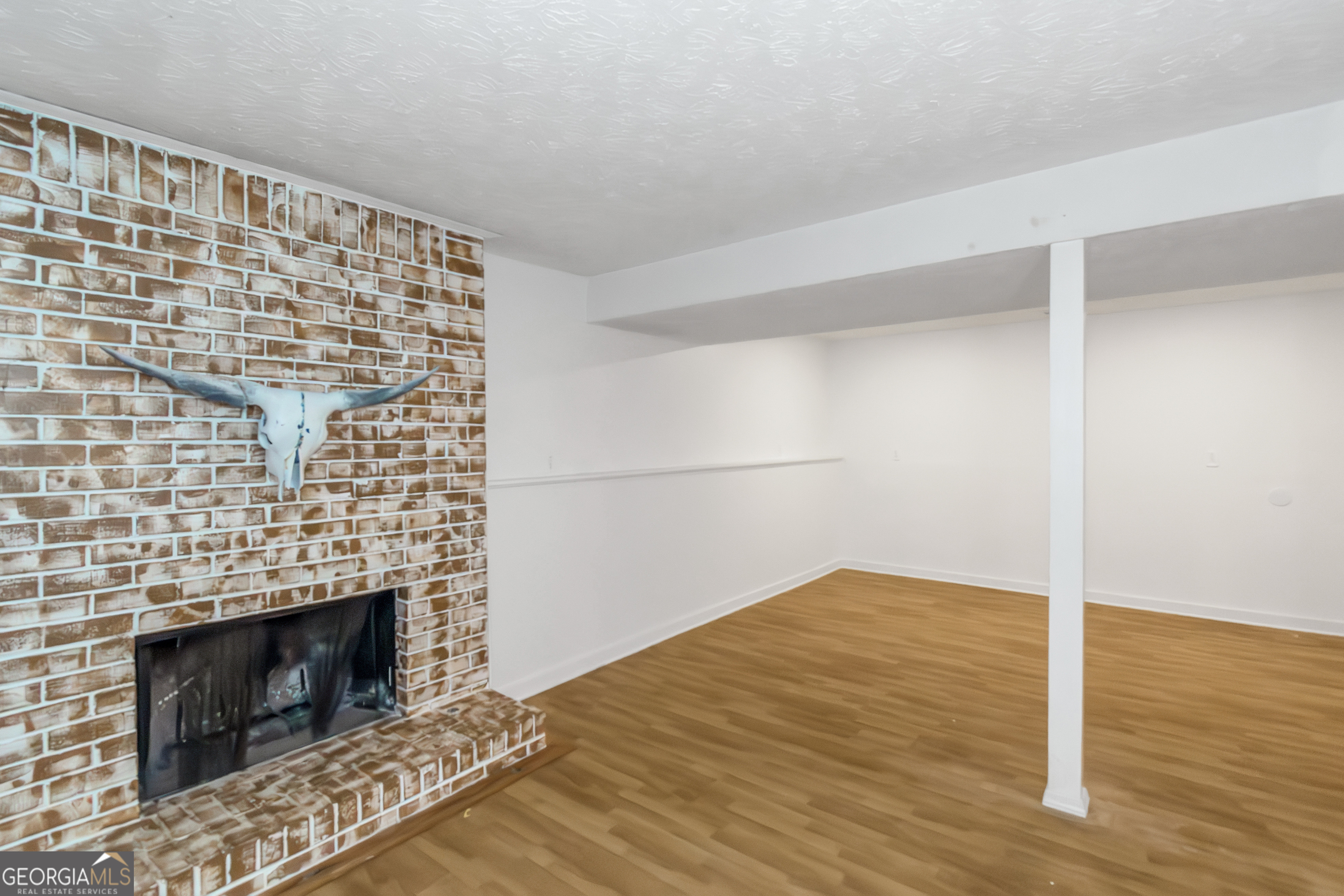 7600 Suwannee Court Jonesboro, GA 30236 - Photo 26 of 35 a view of empty room with wooden floor and fireplace