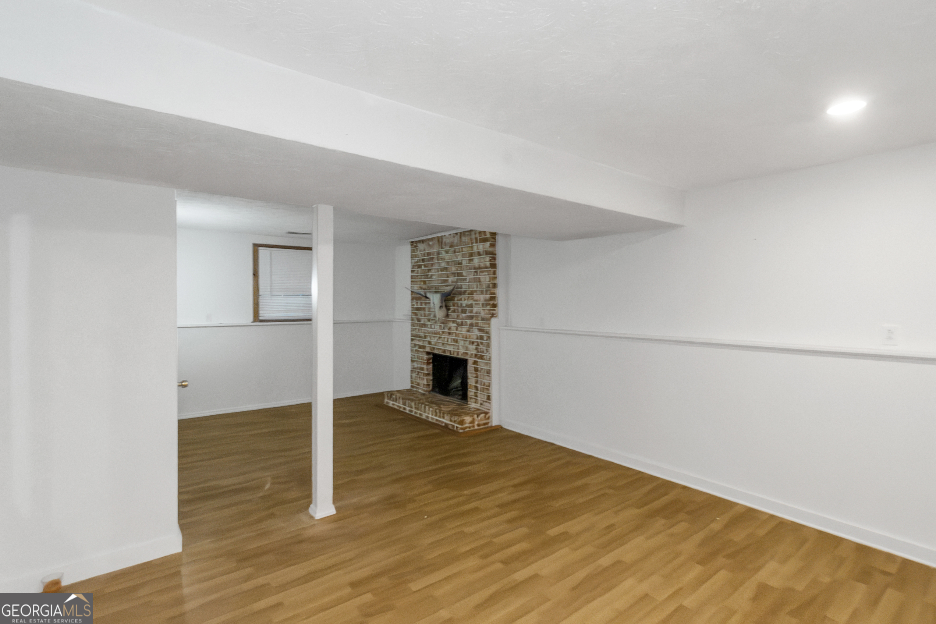 7600 Suwannee Court Jonesboro, GA 30236 - Photo 27 of 35 a view of empty room with wooden floor and fireplace