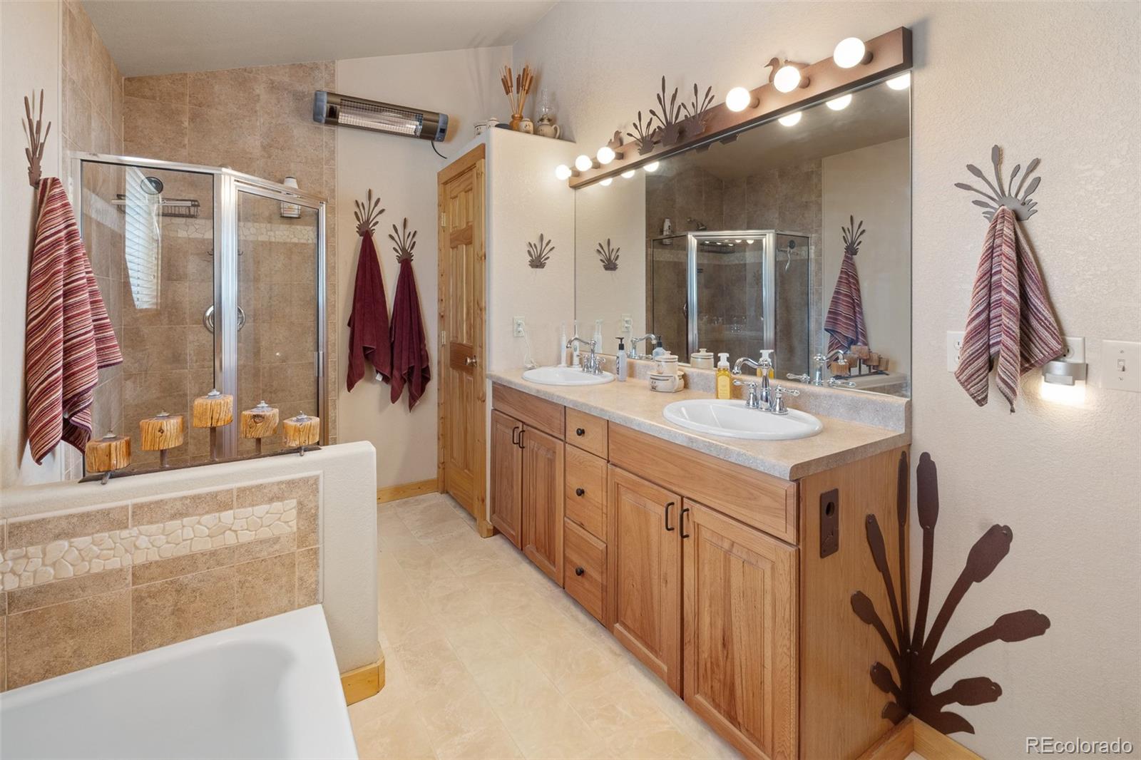 1163 Michigan Hill Road Jefferson, CO 80456 - Photo 34 of 48 a bathroom with a double vanity sink a mirror and shower