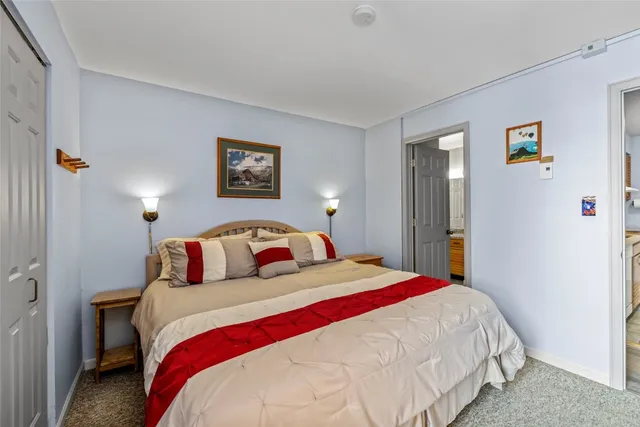 a bedroom with a bed and painting on the wall