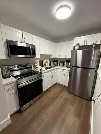 a kitchen with granite countertop a refrigerator a stove top oven a sink and dishwasher