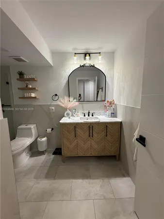 a bathroom with a sink mirror and toilet