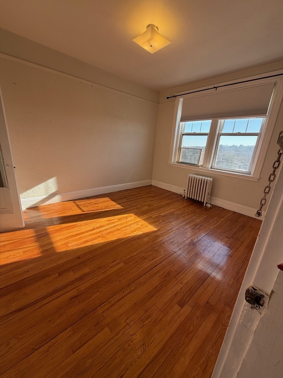 1691 Commonwealth Avenue, Unit 29 Boston, MA 02135 - Photo 2 of 8 an empty room with wooden floor and windows
