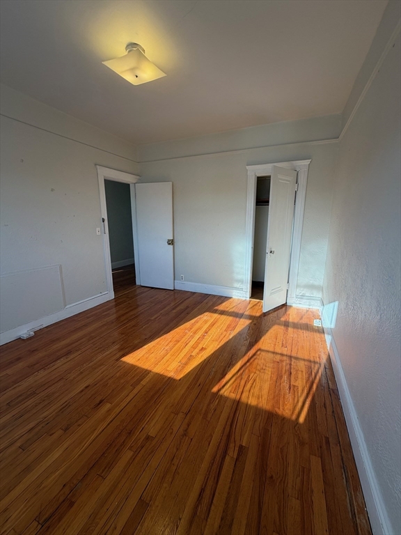 1691 Commonwealth Avenue, Unit 29 Boston, MA 02135 - Photo 3 of 8 a bedroom with a bed and a lamp on table