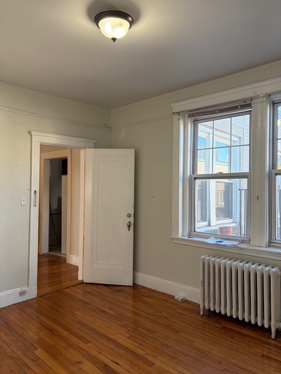 1691 Commonwealth Avenue, Unit 29 Boston, MA 02135 - Photo 4 of 8 a view of an empty room with wooden floor and a window