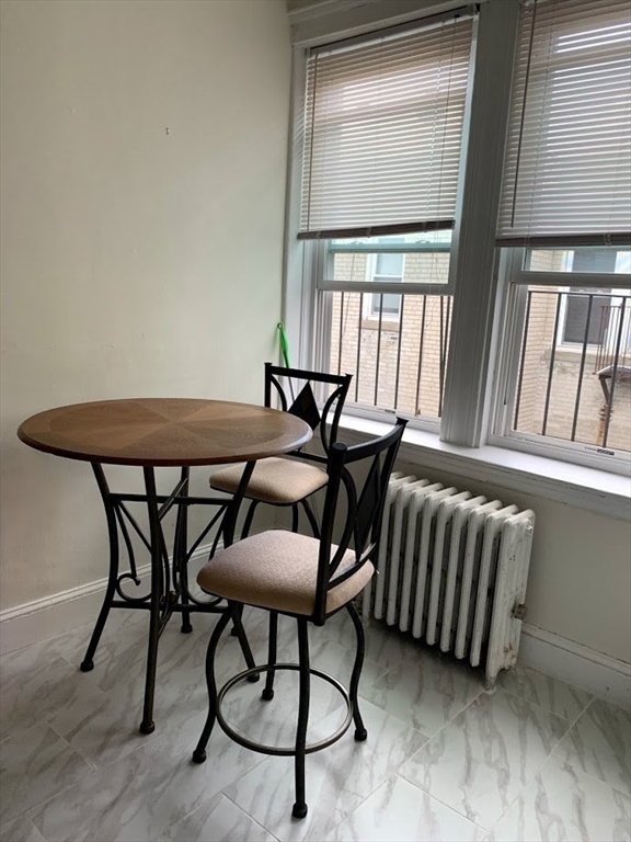1691 Commonwealth Avenue, Unit 29 Boston, MA 02135 - Photo 7 of 8 a view of a dining room with furniture and a window