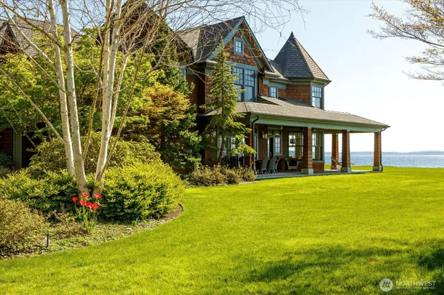 a front view of a house with a big yard and potted plants