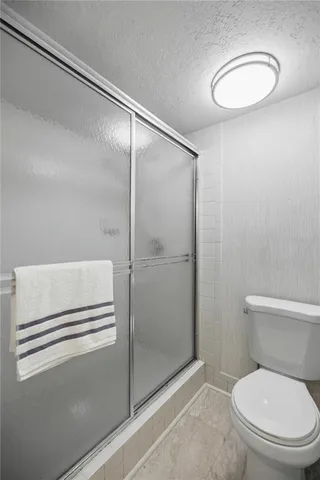 a bathroom with a toilet and a shower