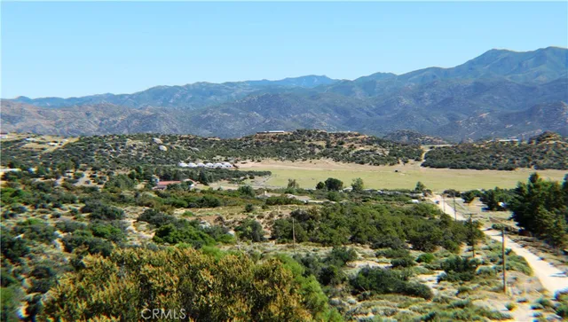 an aerial view of mountain with residential house and green space