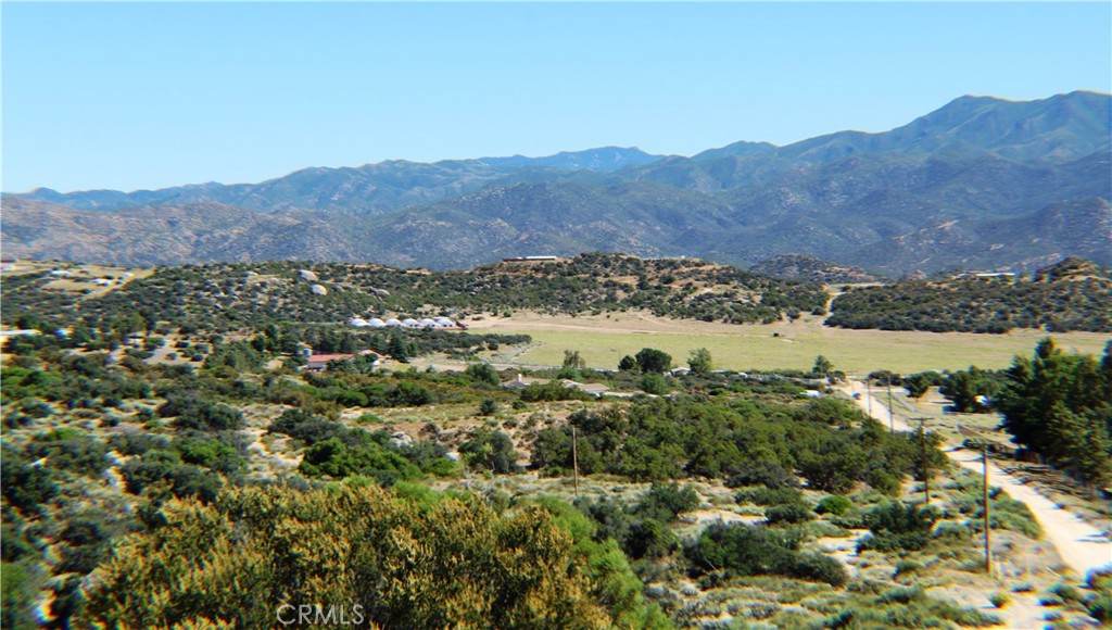 an aerial view of mountain with residential house and green space