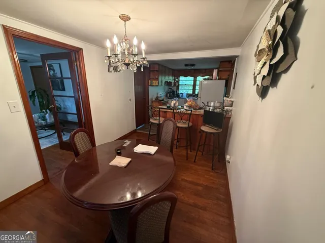 a dining room with furniture a chandelier and wooden floor