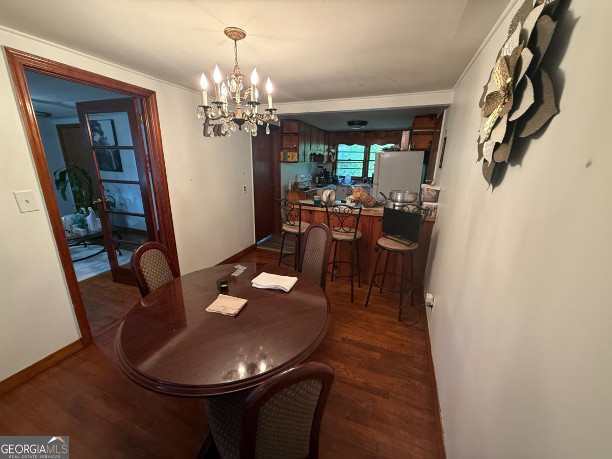 4510 Browns Bridge Road Gainesville, GA 30504 - Photo 5 of 13 a dining room with furniture a chandelier and wooden floor