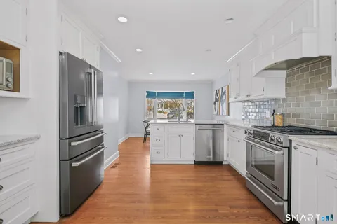 a kitchen with white cabinets and stainless steel appliances