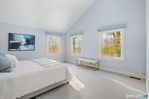 a bedroom with a bed and two windows