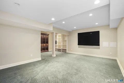 a view of an empty room with wooden floor and windows