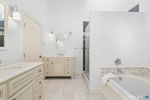 a spacious bathroom with a granite countertop sink a mirror a vanity and a bathtub
