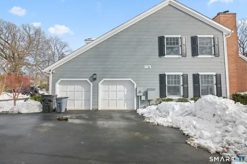 a front view of a house with a snow on the road