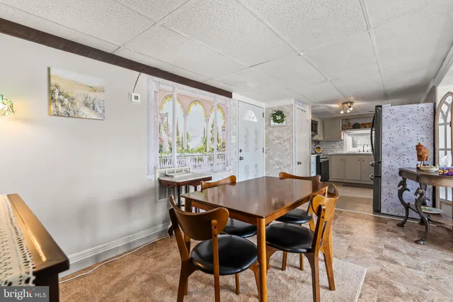 a view of a dining room and kitchen with furniture window and wooden floor