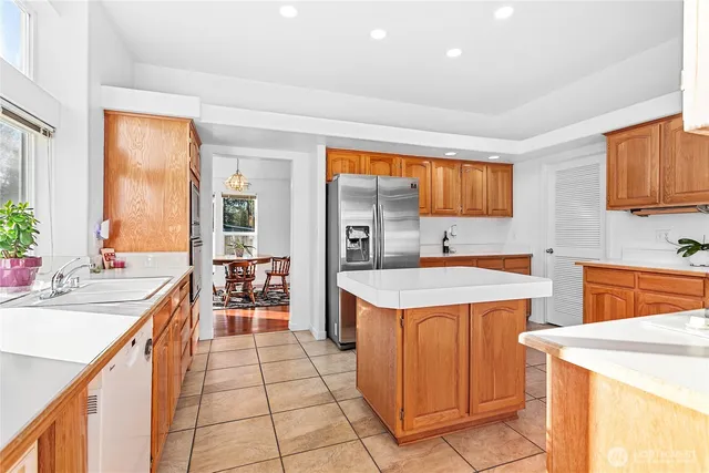 a view of a kitchen with kitchen island a sink a counter top space and appliances