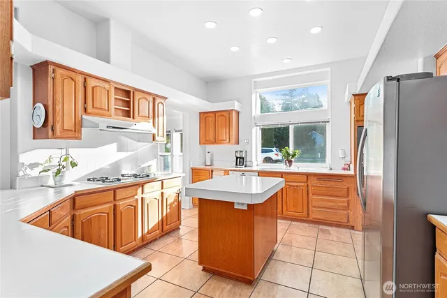 a kitchen with stainless steel appliances granite countertop a sink and a refrigerator