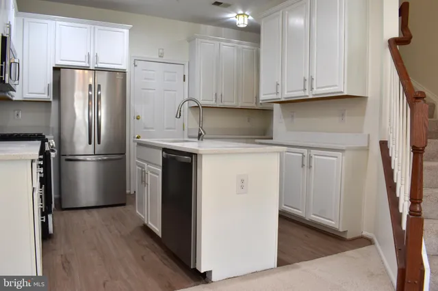 a kitchen with stainless steel appliances a refrigerator sink and cabinets