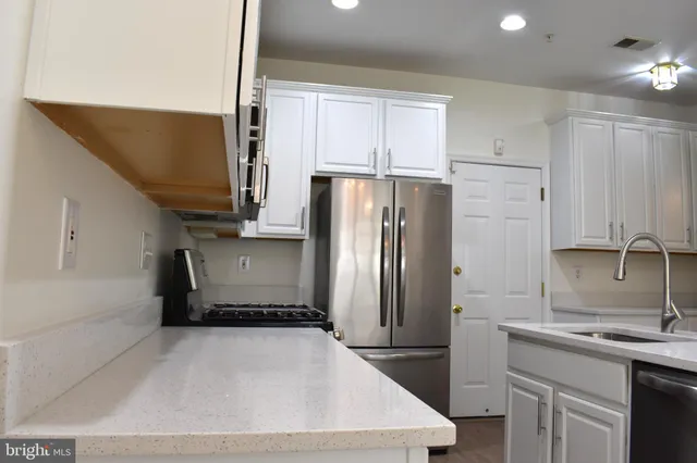 a kitchen with stainless steel appliances a refrigerator sink and microwave