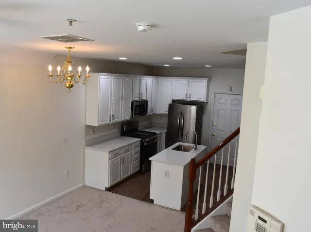 a kitchen that has a lot of cabinets and stainless steel appliances