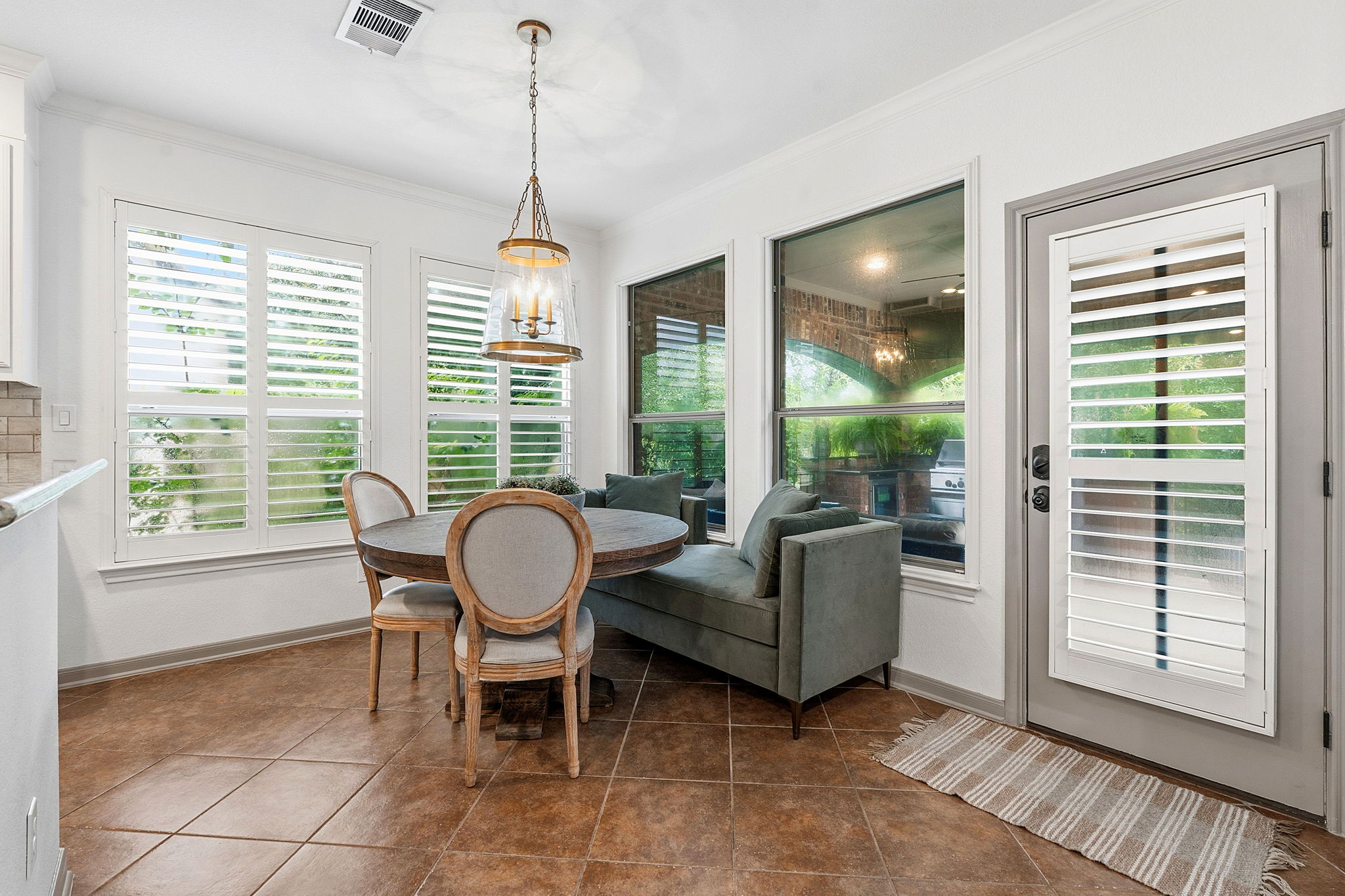 12321 Edenvale Path Austin, TX 78732 - Photo 13 of 36 A charming dining space with warm tiled floors and ample natural light through well-appointed windows.