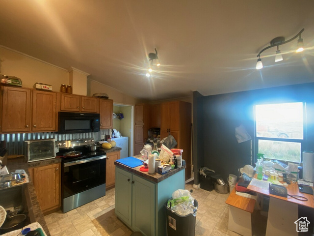 4963 20810 West Duchesne, UT 84021 - Photo 5 of 28 Kitchen featuring stainless steel electric range oven, black microwave, a center island, brown cabinetry, and vaulted ceiling