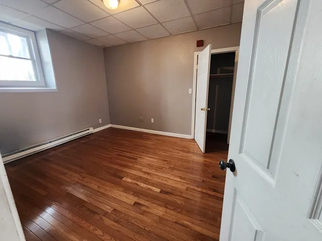 a view of empty room with window and wooden floor