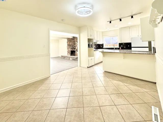 a view of a kitchen with kitchen island white cabinets and black appliances