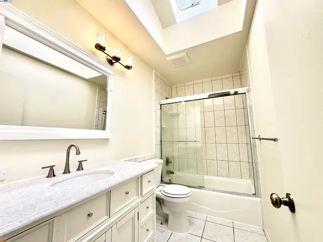 a bathroom with a granite countertop sink a toilet and shower