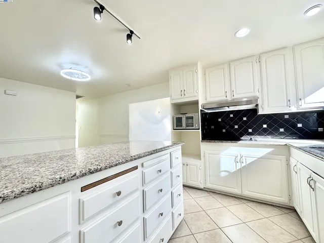 a kitchen with granite countertop white cabinets white appliances and granite counter tops
