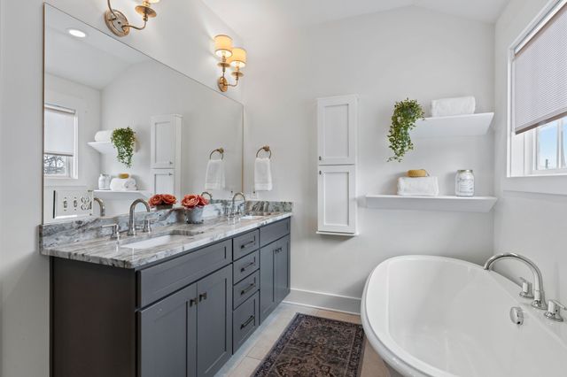 a bathroom with a sink and a mirror with bathtub