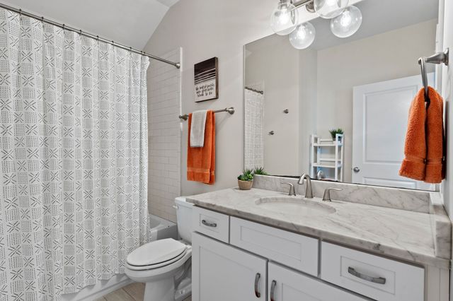 a bathroom with a granite countertop sink a toilet and a mirror