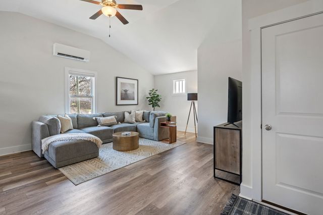 a living room with furniture wooden floor and a window
