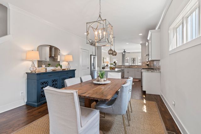 a view of a dining room with furniture a chandelier and wooden floor