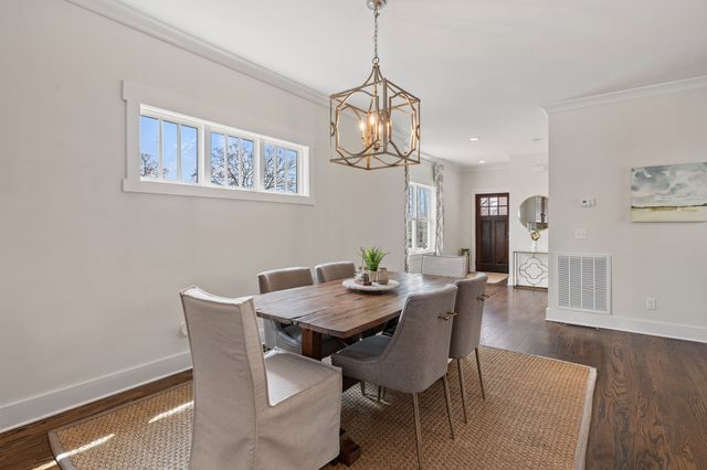a view of a dining room with furniture wooden floor and a chandelier