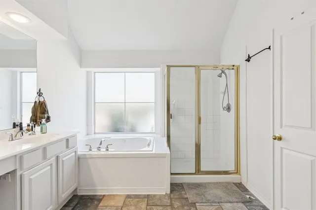 a large bathroom with a double vanity sink mirror and bathtub