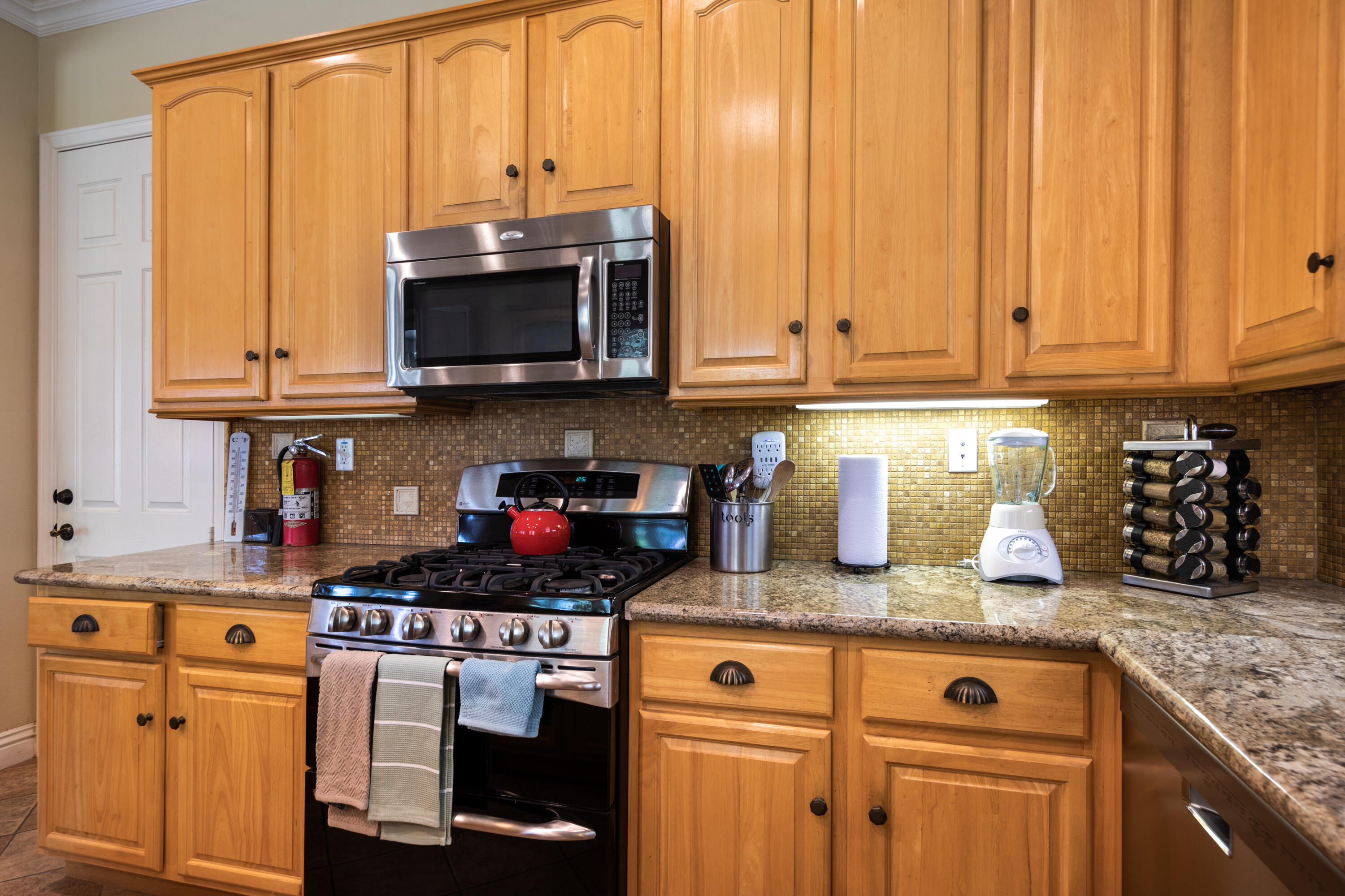 49475 Redford Way Indio, CA 92201 - Photo 26 of 45 a kitchen with granite countertop a stove a sink and a microwave