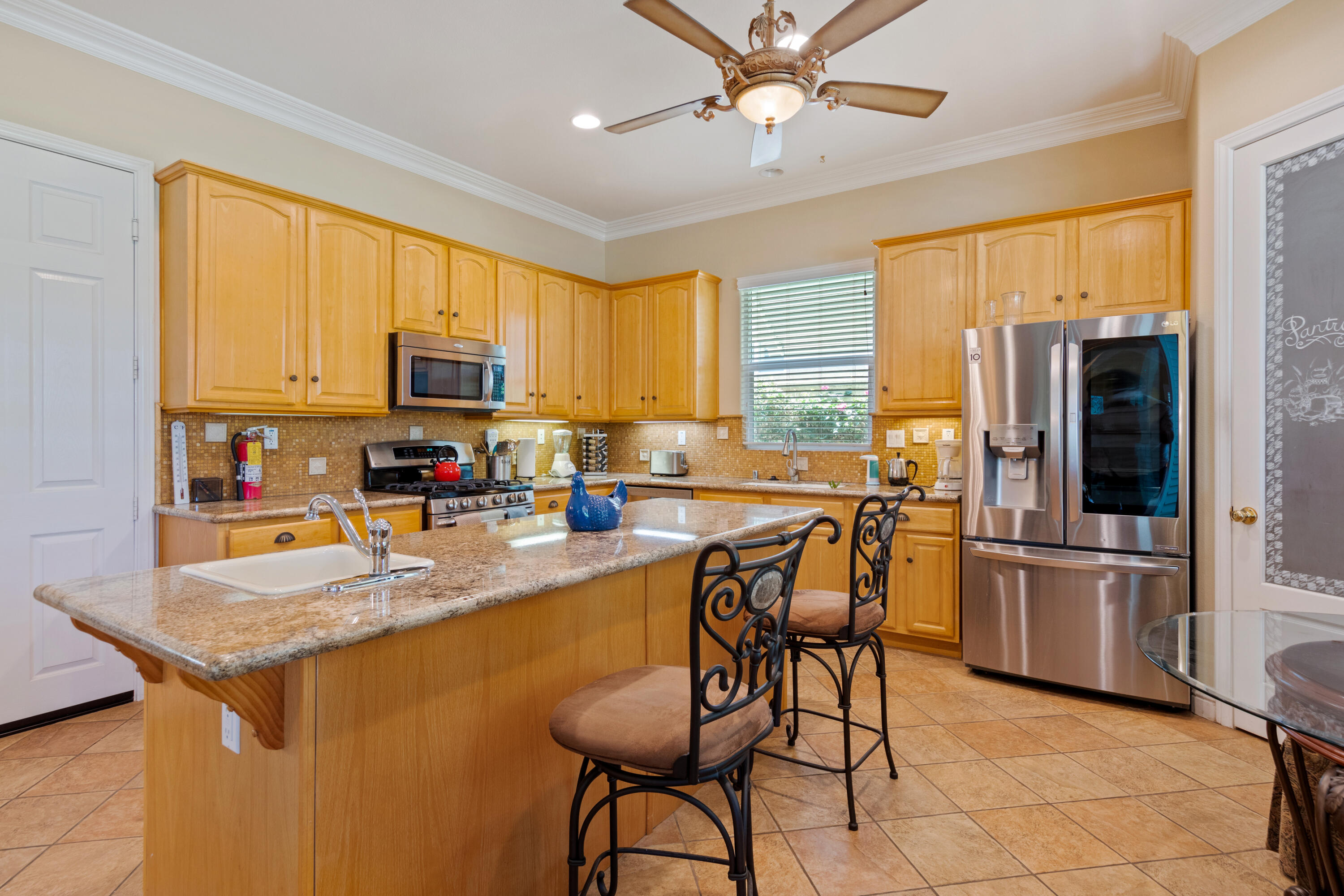 49475 Redford Way Indio, CA 92201 - Photo 28 of 45 a kitchen with stainless steel appliances granite countertop a stove a sink a microwave a refrigerator cabinets and dining table