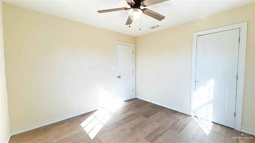 204 South Mcdaniel Street Edcouch, TX 78538 - Photo 7 of 9 an empty room with wooden floor and fan