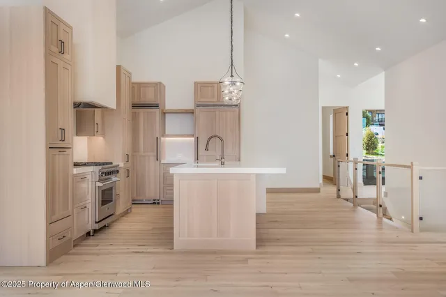 a kitchen with granite countertop a sink a center island a counter space and cabinets