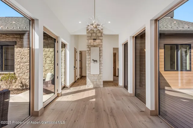 a view of a hallway with wooden floor and a livingroom