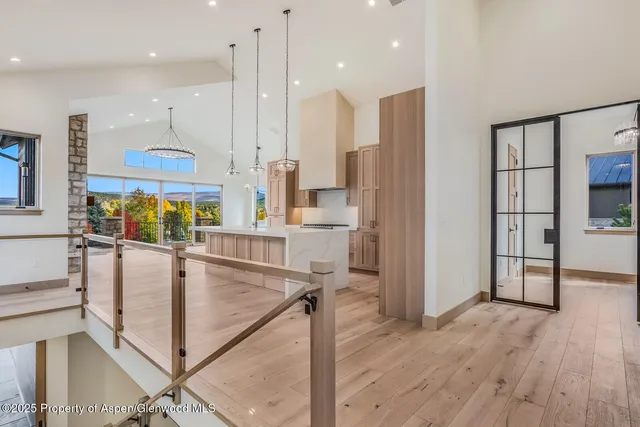 a kitchen with kitchen island granite countertop wooden floor a refrigerator and a sink