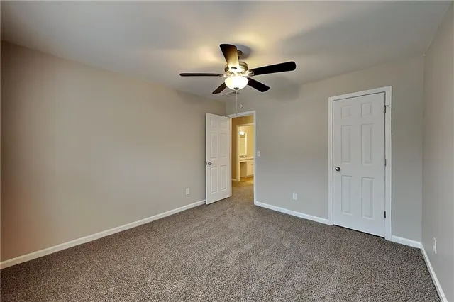 a view of an empty room and a ceiling fan window