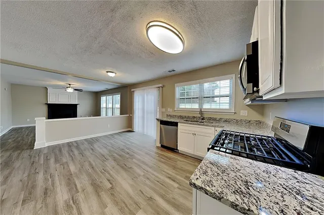 a kitchen with a refrigerator and a stove top oven