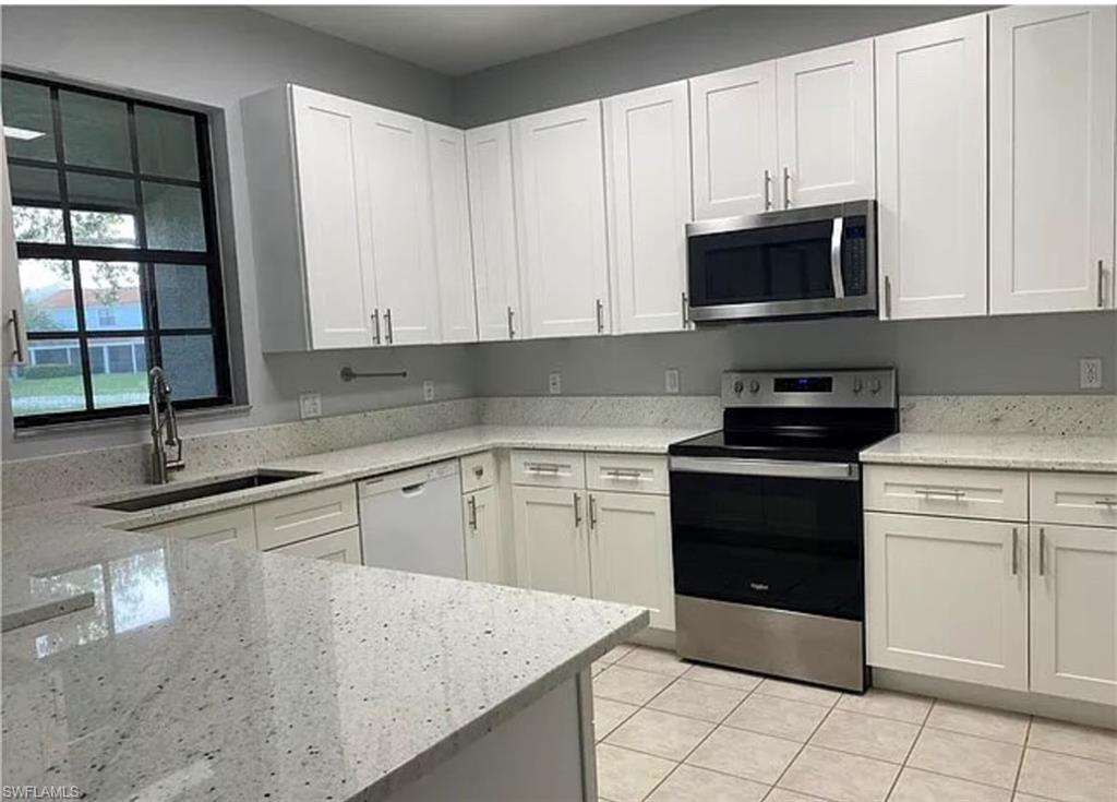 14712 Sutherland Avenue Naples, FL 34119 - Photo 1 of 8 a kitchen with stainless steel appliances granite countertop a sink and a stove
