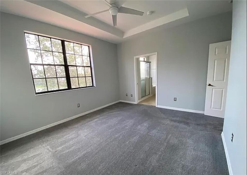 14712 Sutherland Avenue Naples, FL 34119 - Photo 4 of 8 an empty room with windows and chandelier fan