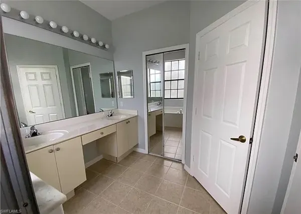 a bathroom with a double vanity sink a mirror and a bathtub